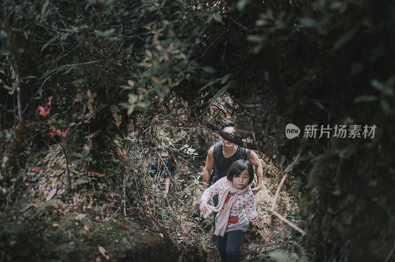 asian chinese male hiker exploring mossy forest in cameron highland walking with his daughter